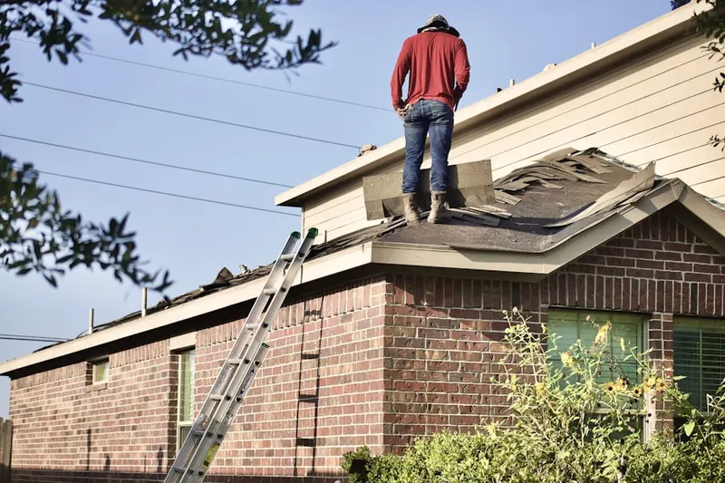 Professional roofer working on a residential roof in Amherst Meadows